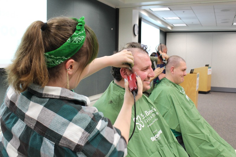 KACC Student Shaving hear of CSL Behring staff member for St. Baldrick's fundraiser